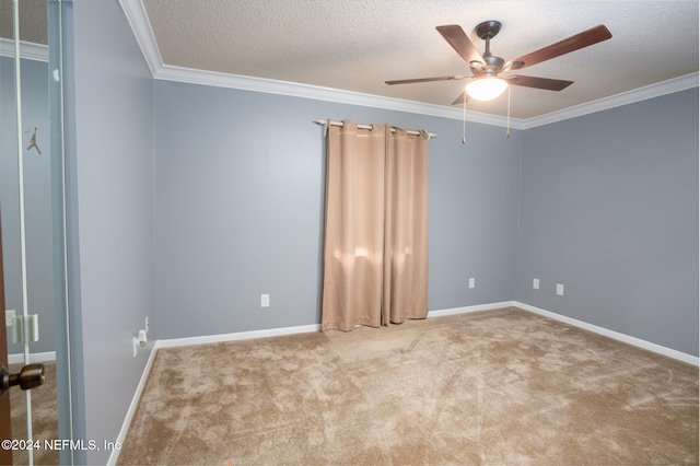 unfurnished room with ceiling fan, carpet, a textured ceiling, and ornamental molding