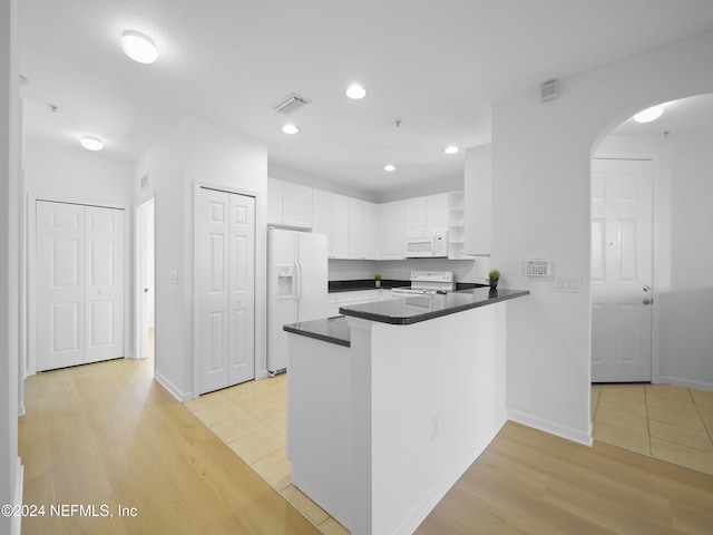 kitchen featuring white cabinets, white appliances, kitchen peninsula, and light hardwood / wood-style flooring