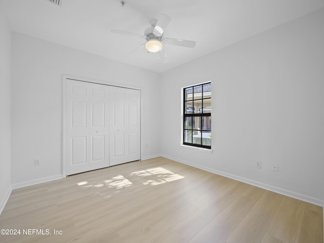 unfurnished bedroom featuring ceiling fan, a closet, and light hardwood / wood-style floors