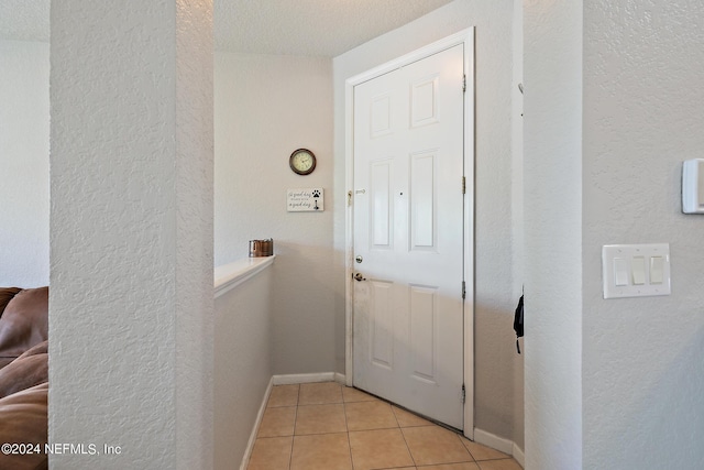 entryway featuring light tile patterned floors and a textured ceiling