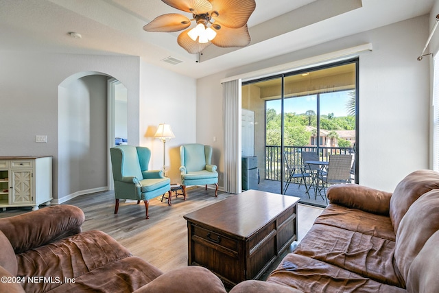 living room with ceiling fan and light hardwood / wood-style flooring