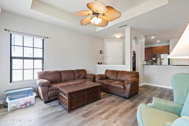 living room with ceiling fan and light hardwood / wood-style floors