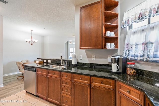 kitchen with pendant lighting, dishwasher, sink, and dark stone counters