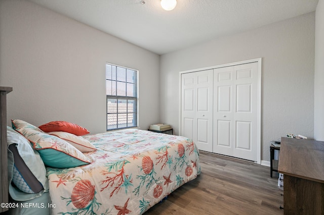 bedroom with dark hardwood / wood-style flooring and a closet