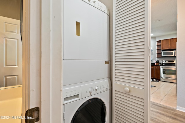 clothes washing area with stacked washer / dryer and light hardwood / wood-style floors