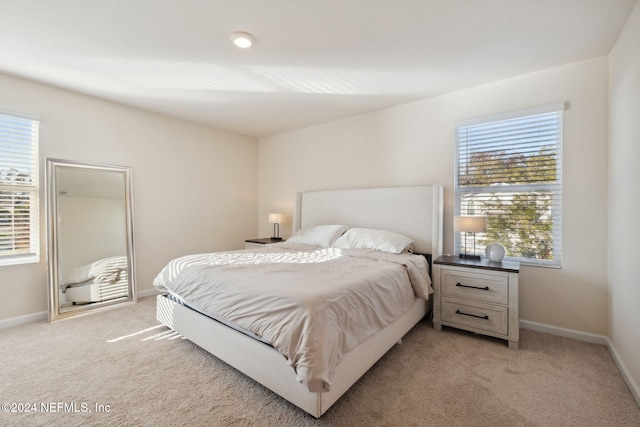 carpeted bedroom featuring multiple windows