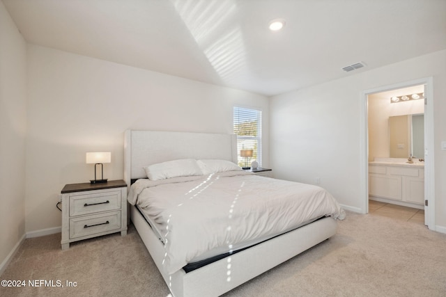 carpeted bedroom with connected bathroom and sink