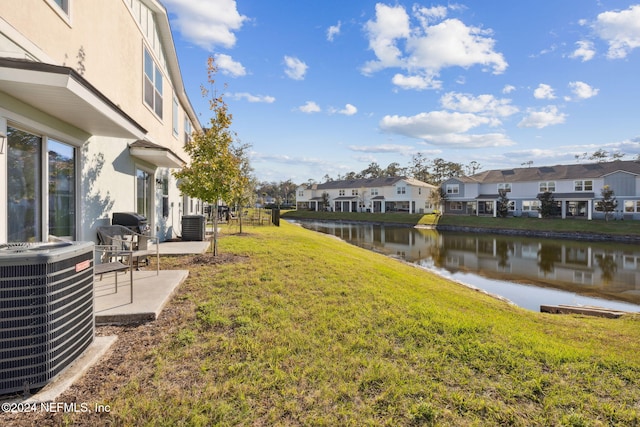 view of yard featuring central AC, a patio area, and a water view