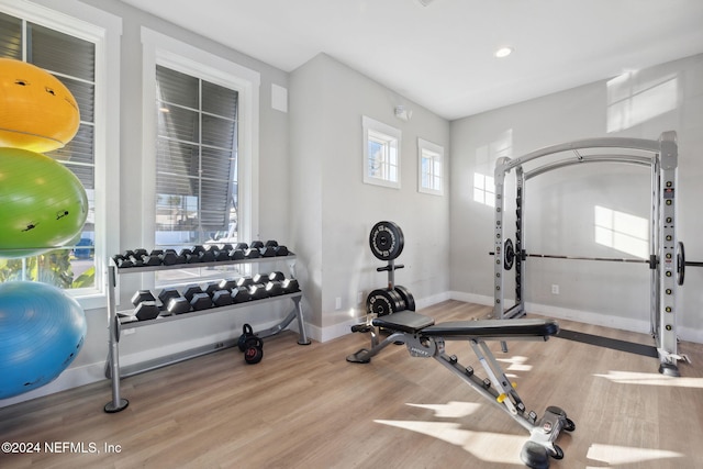 exercise room with light wood-type flooring