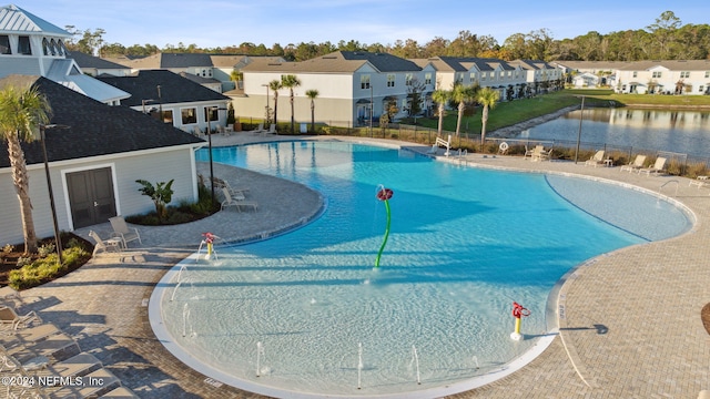 view of pool with a water view and a patio