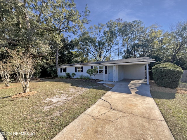 ranch-style home featuring a front lawn and a carport