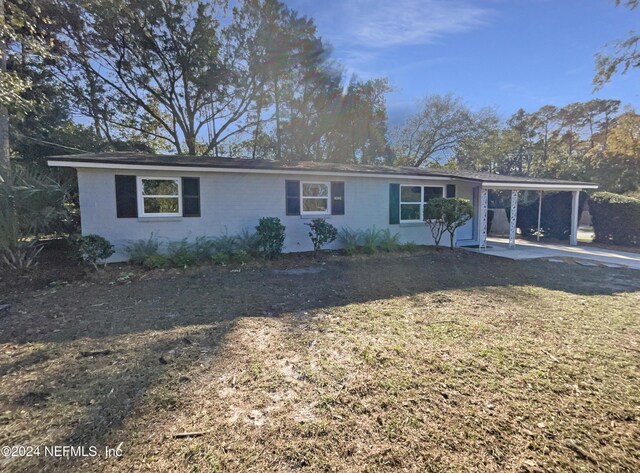 ranch-style home featuring a front lawn and a carport