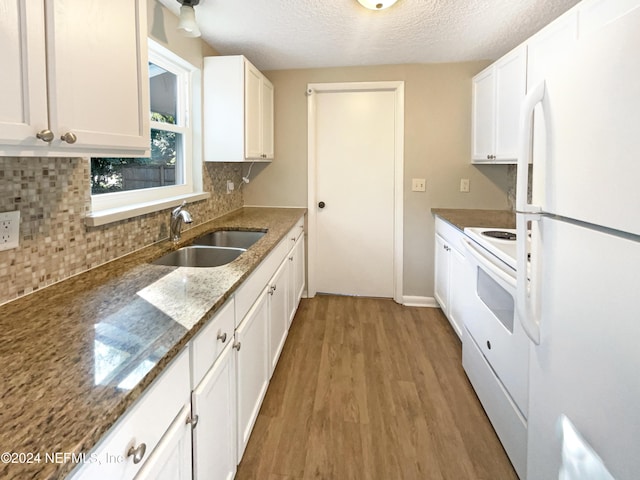 kitchen with white appliances, white cabinets, sink, light hardwood / wood-style flooring, and a textured ceiling