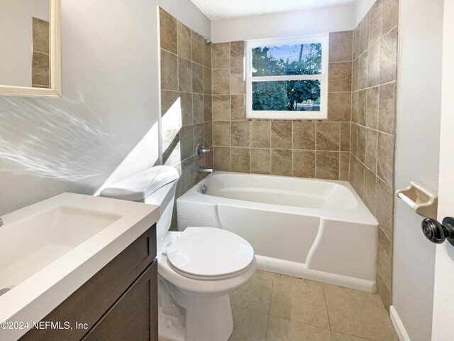 full bathroom featuring toilet, tile patterned flooring, vanity, and tiled shower / bath