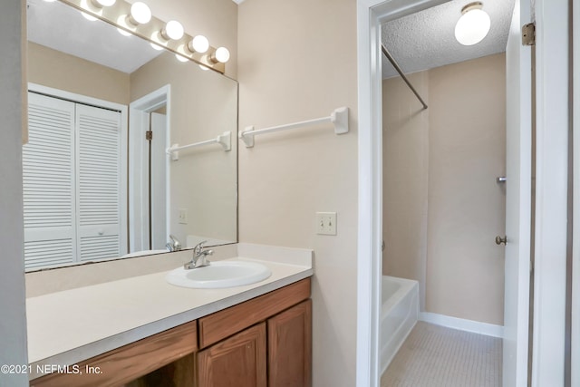 bathroom with tile patterned floors, vanity, shower / bathtub combination, and a textured ceiling