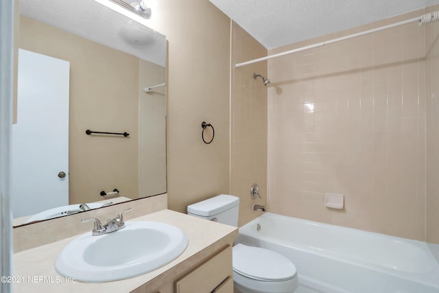 full bathroom with vanity, a textured ceiling, toilet, and tiled shower / bath