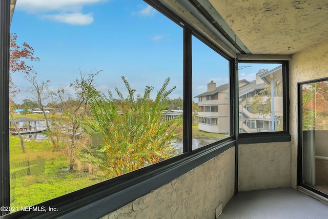 unfurnished sunroom featuring a water view