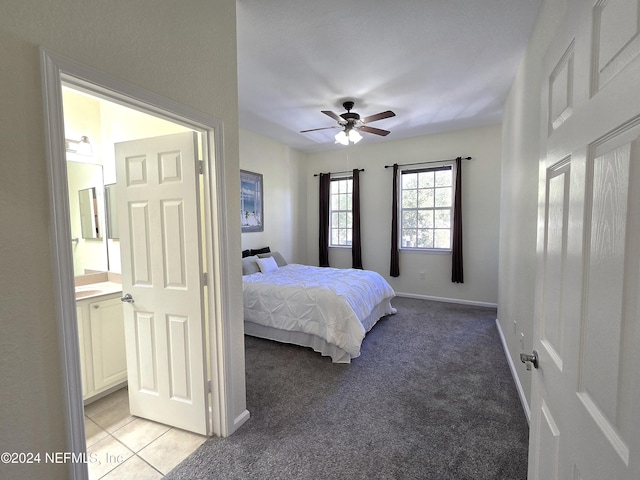 bedroom featuring light carpet, ensuite bath, and ceiling fan