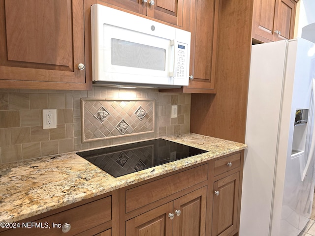 kitchen with light stone counters, white appliances, and tasteful backsplash