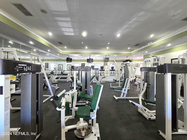 gym featuring crown molding and a tray ceiling