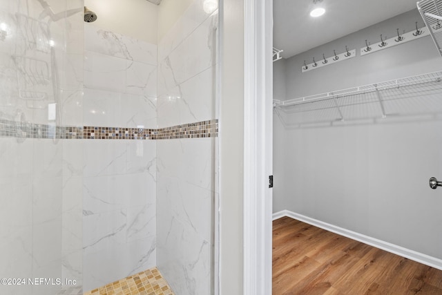 bathroom featuring hardwood / wood-style floors and tiled shower