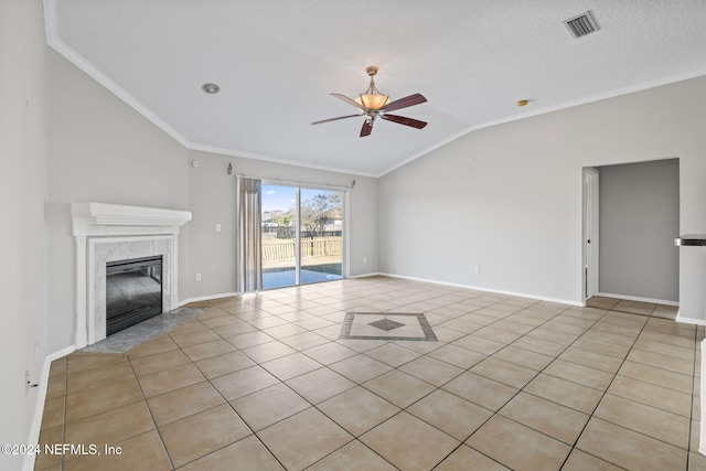 unfurnished living room featuring ceiling fan, crown molding, vaulted ceiling, a fireplace, and light tile patterned flooring