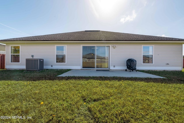 rear view of property featuring cooling unit, a yard, and a patio