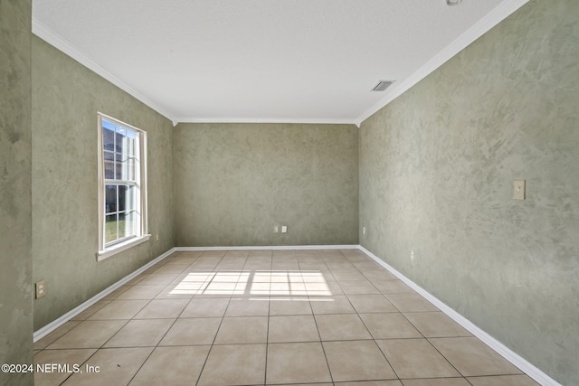 tiled spare room featuring crown molding