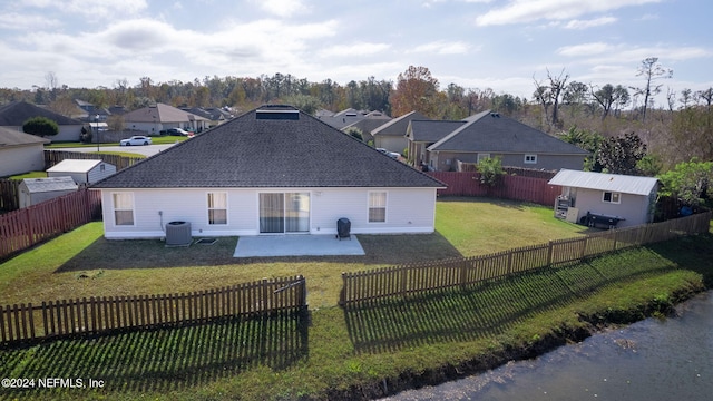 rear view of house with central AC unit, a patio area, and a lawn