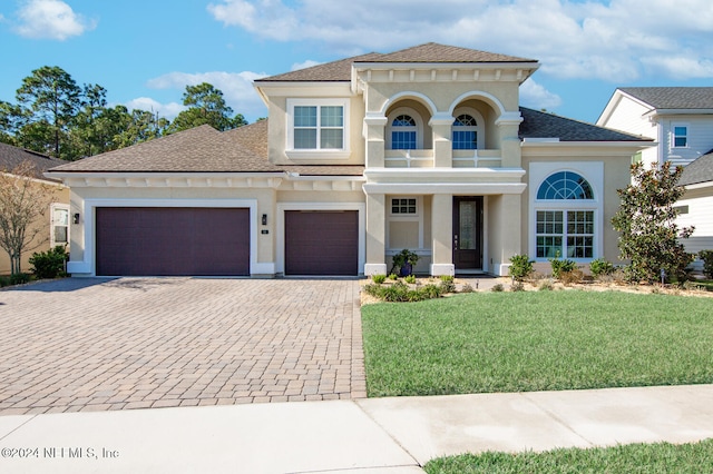 mediterranean / spanish-style home featuring a garage, a balcony, and a front lawn