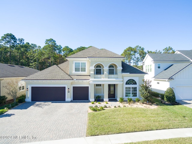 view of front of property featuring a balcony and a front lawn