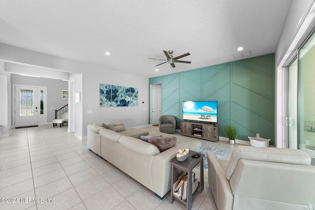 living room with light tile patterned floors, a textured ceiling, and ceiling fan