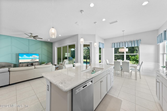 kitchen featuring white cabinets, a kitchen island with sink, sink, dishwasher, and hanging light fixtures