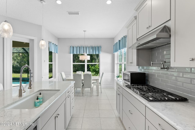 kitchen with pendant lighting, plenty of natural light, sink, and appliances with stainless steel finishes