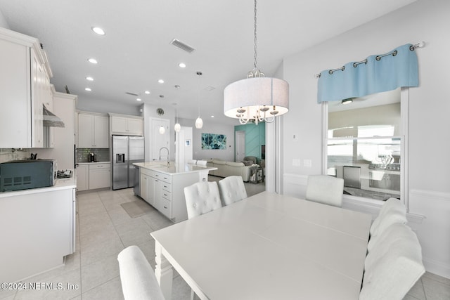 dining space featuring a chandelier, light tile patterned floors, and sink