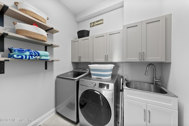 laundry room with cabinets, sink, and washing machine and clothes dryer