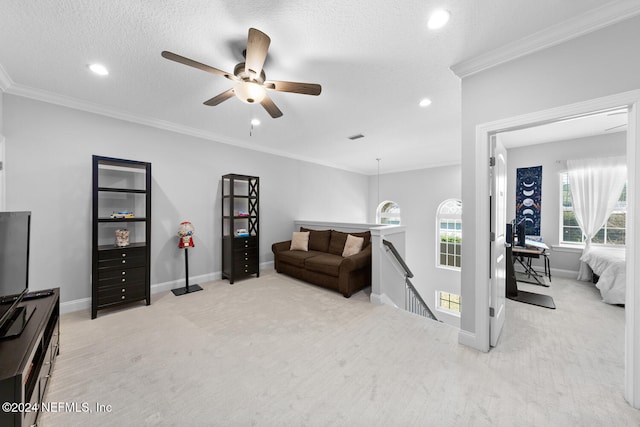 living room featuring light carpet, crown molding, ceiling fan, and a textured ceiling