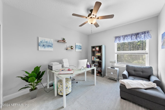 carpeted office featuring a textured ceiling and ceiling fan