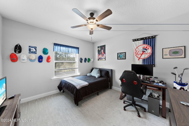 carpeted bedroom featuring a textured ceiling and ceiling fan