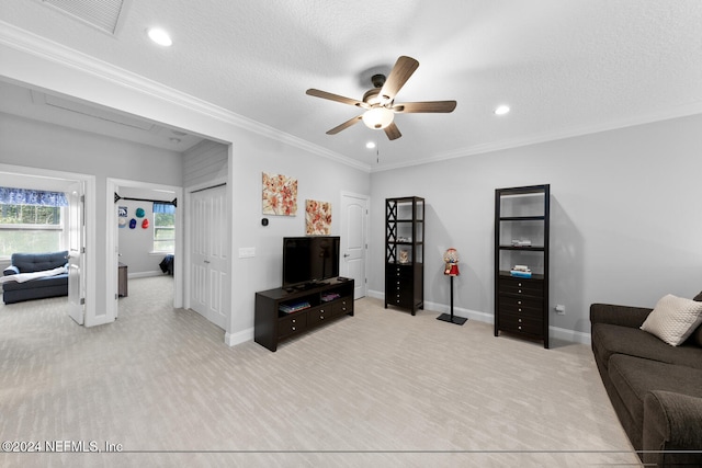 carpeted living room featuring crown molding, ceiling fan, and a textured ceiling