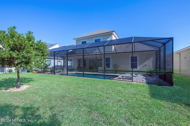 rear view of property with a lanai, a yard, and a patio