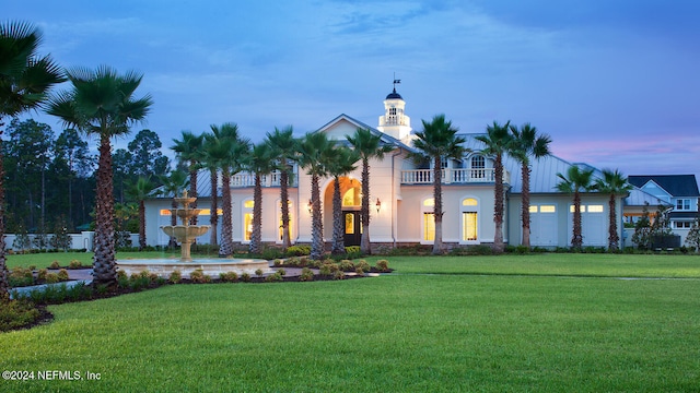 view of front of house with a balcony and a yard