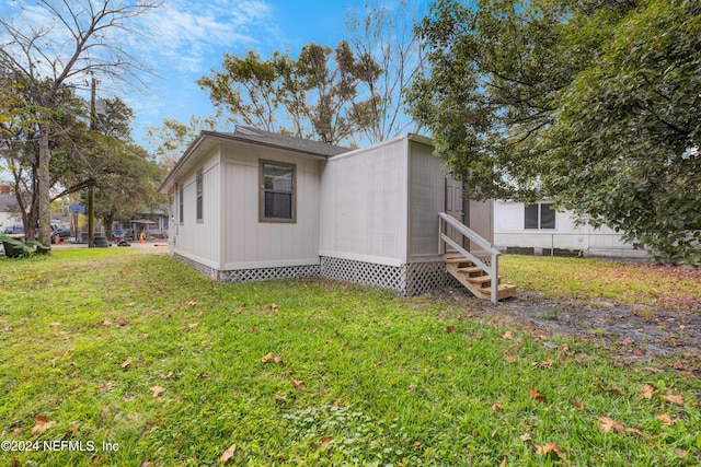 view of side of home with a yard