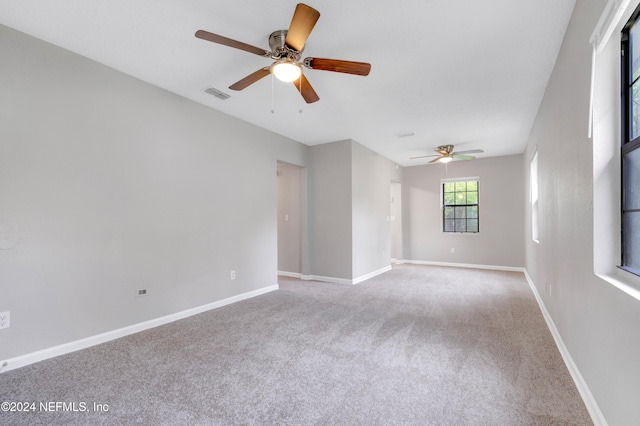 carpeted spare room featuring ceiling fan