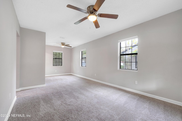 spare room featuring ceiling fan, a healthy amount of sunlight, and light carpet