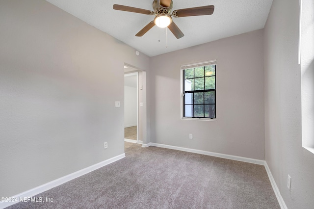 carpeted spare room with ceiling fan and a textured ceiling