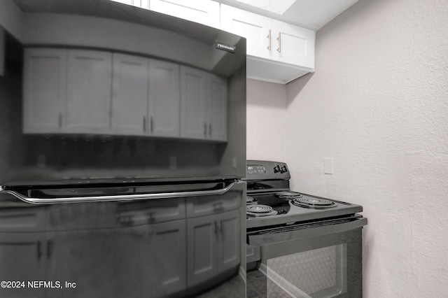 kitchen featuring gray cabinetry, black electric range oven, and white cabinetry