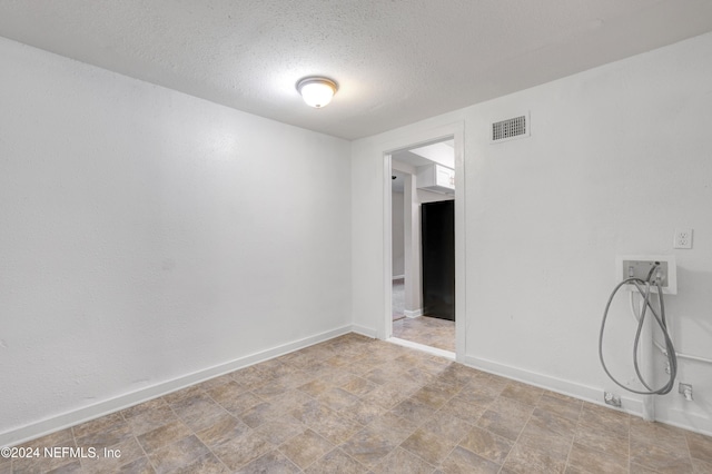 unfurnished room featuring a textured ceiling