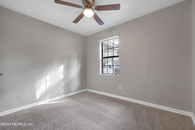 carpeted spare room featuring a textured ceiling and ceiling fan