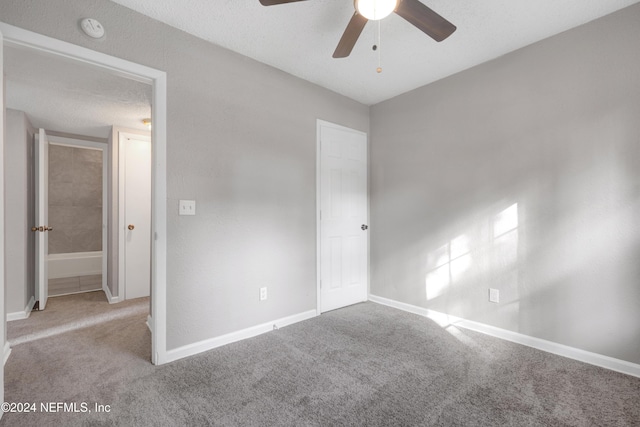 unfurnished bedroom featuring ceiling fan, light colored carpet, and a textured ceiling